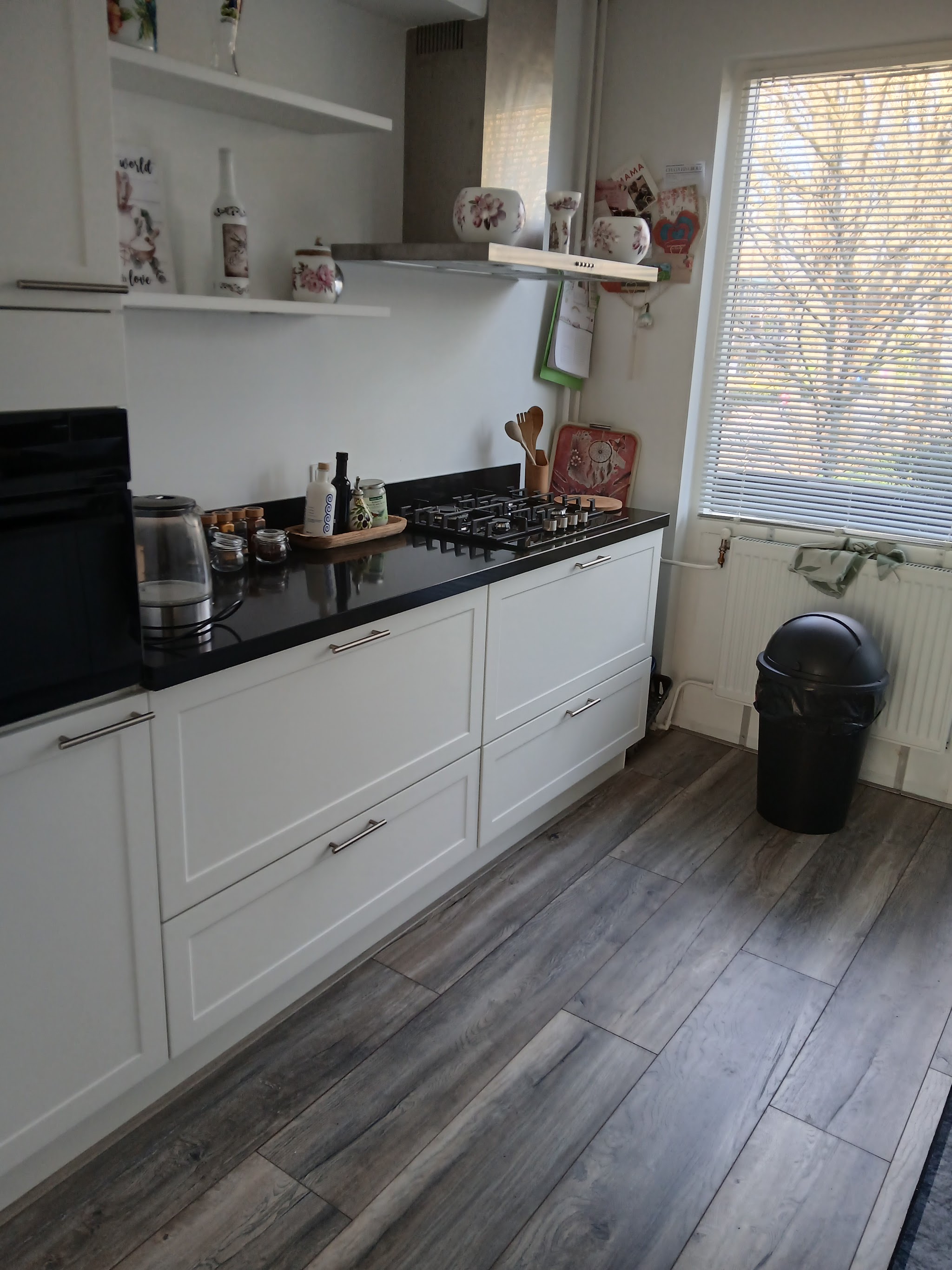 Witte keuken met paneelfronten, zwart werkblad en gaskookplaat