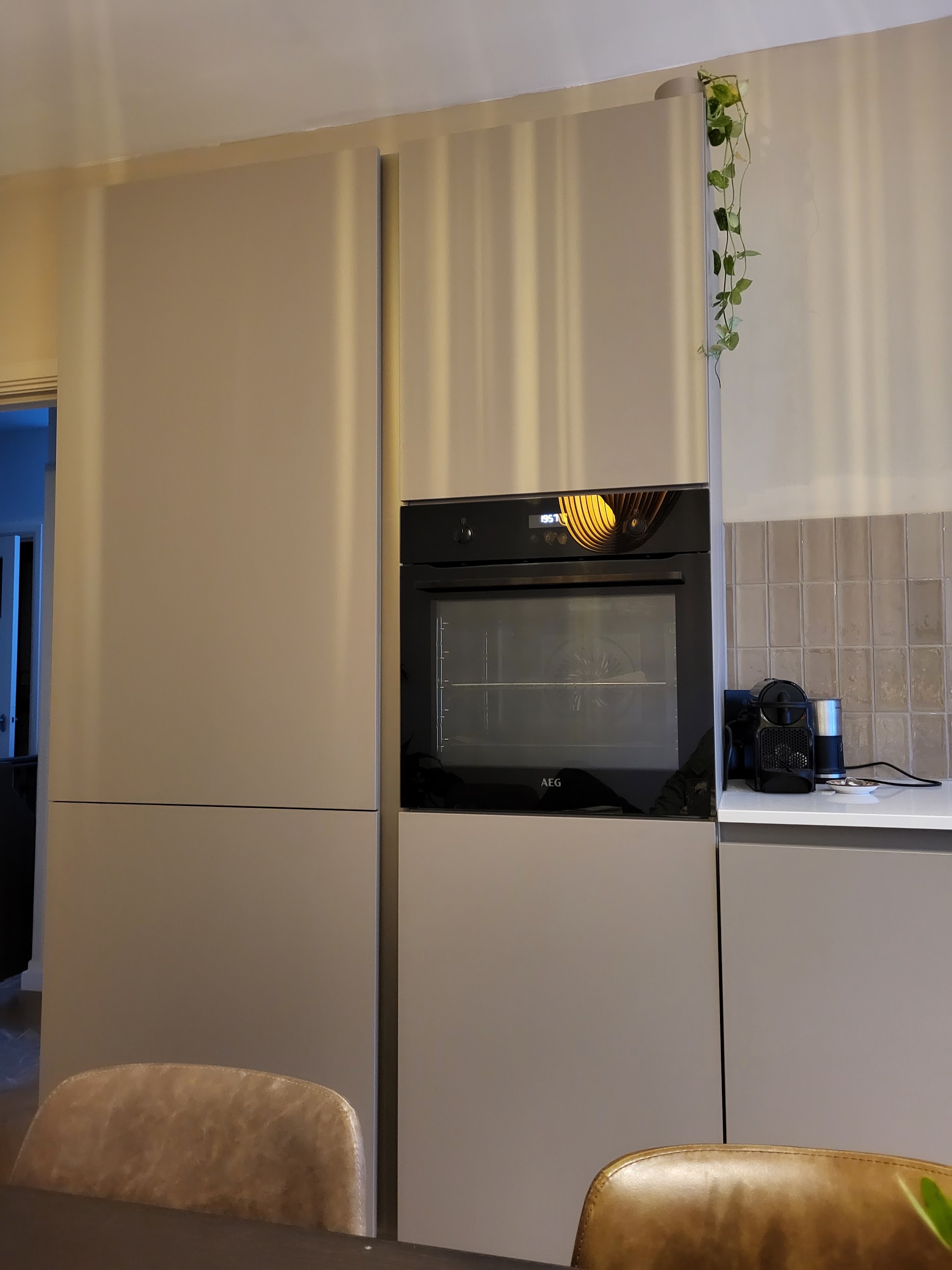 Hoge greige kastenwand met ingebouwde oven